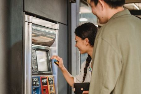 Travel Money - Content couple using ticket machine in underground