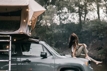 Car Camping - A Woman Sitting on the Hood of the Car