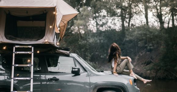Car Camping - A Woman Sitting on the Hood of the Car
