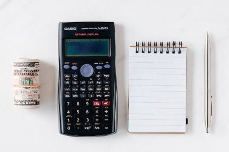 Budget - Composition of calculator with paper money and notebook with pen