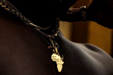 Continent - Close-up of a Man Wearing a Necklace in the Shape of Africa