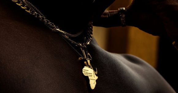 Continent - Close-up of a Man Wearing a Necklace in the Shape of Africa