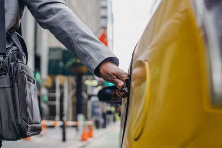 Rich Travel - Black man touching door of taxi