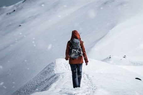 Adventure - Back View of a Person in Winter Clothing Walking Alone on Snow Covered Ground