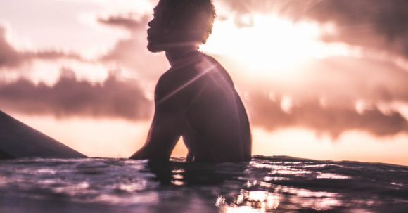 Wellness Travel - Unrecognizable black man relaxing in sea water at sundown